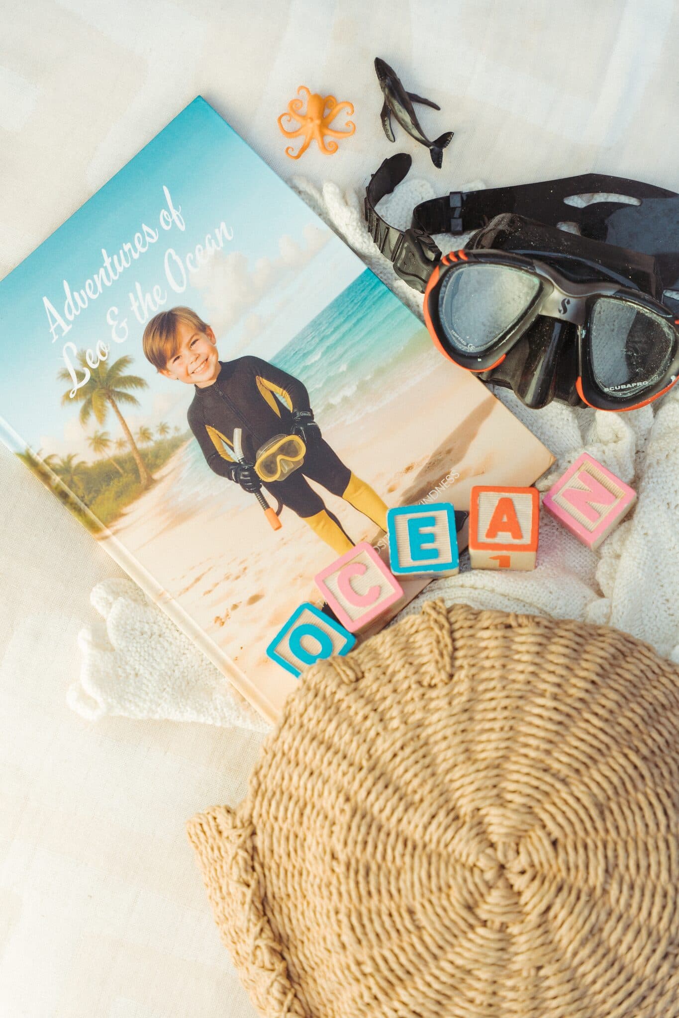 The ocean hardcover laid out with a snorkel mask and wooden letter blocks spelling OCEAN