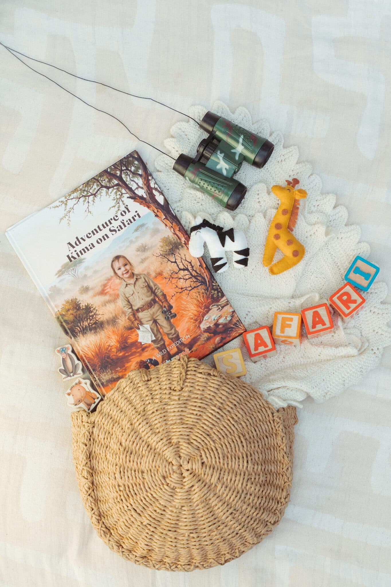 The safari book starring a girl, laid out with binoculars and a toy giraffe