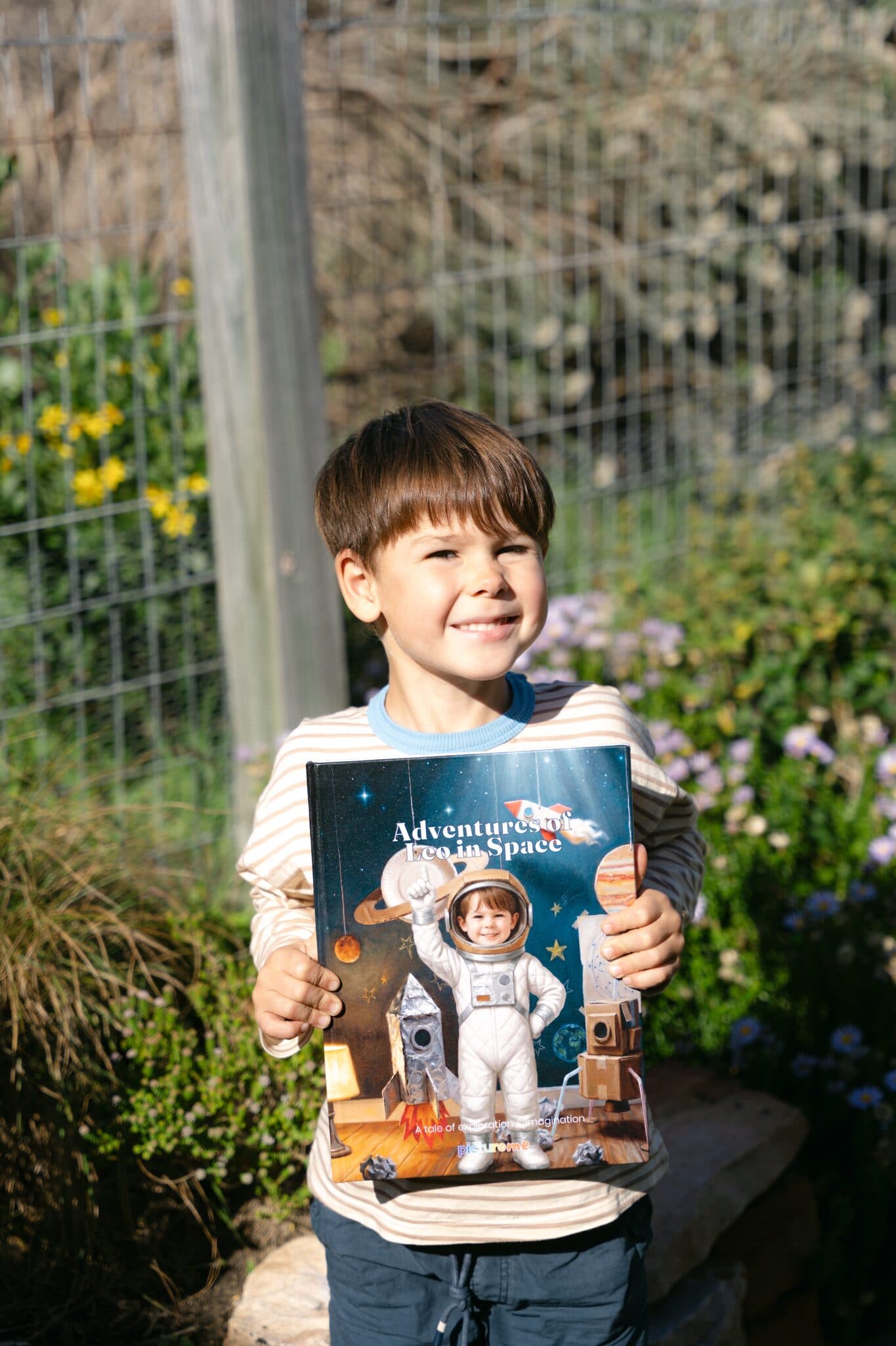 A boy holding his hardcover of Adventures of Leo in Space