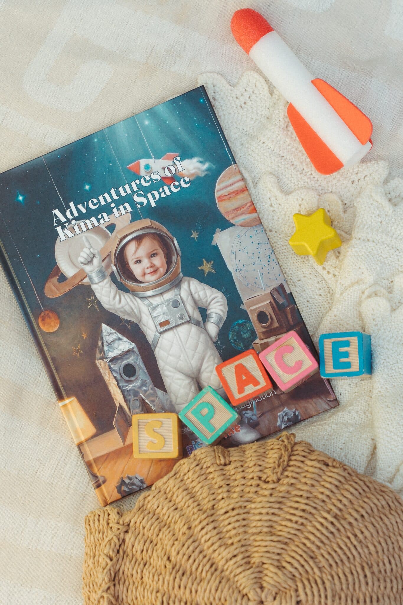 The space book starring a girl, laid out with a toy rocket and letter blocks